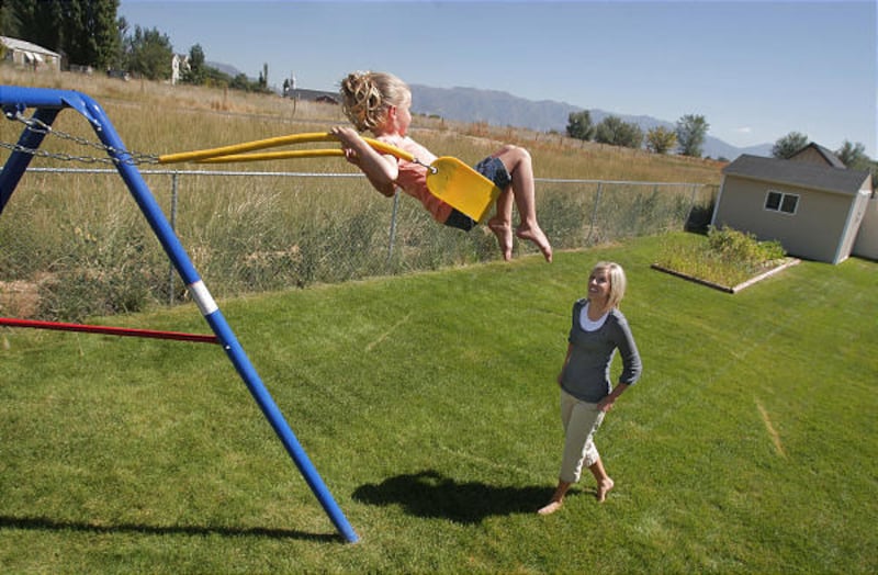 Natalie Argyle, right, and her daughter Allie, 5, enjoy their backyard in Syracuse, which may be in path of a Legacy extension.