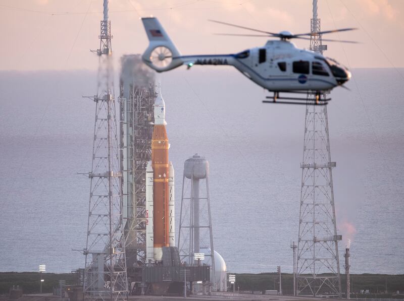 A NASA helicopter flies past the agency’s Space Launch System rocket in Cape Canaveral, Florida.