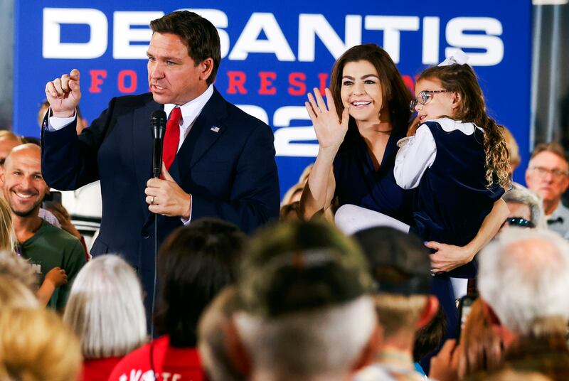 Casey DeSantis holds one of their daughters as she joins her husband, Florida Gov. Ron DeSantis, during a town hall.