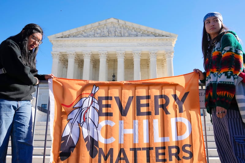 Demonstrators stand outside of the U.S. Supreme Court, as the court hears arguments over the Indian Child Welfare Act, Wednesday, Nov. 9, 2022, in Washington.