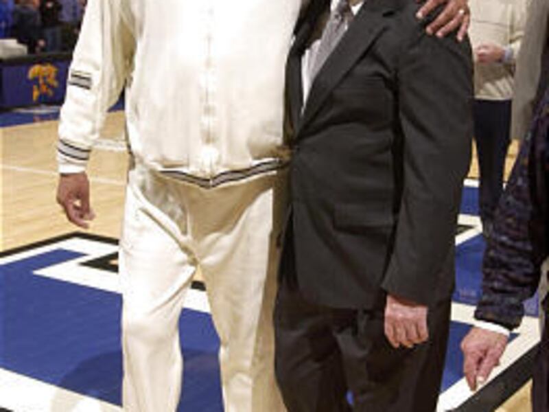 Former Kentucky basketball player Melvin Turpin walks off the court with Joe B. Hall