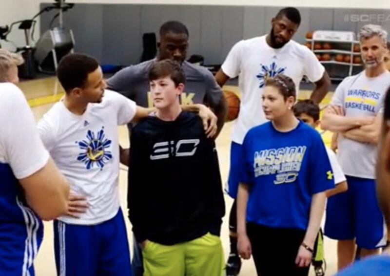 Stephen Curry explains to the Wagner twins that they will serve as honorary captains during a Warriors game.