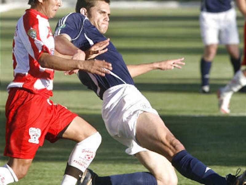 BYU's Steve Magleby slides in front of Yakima's Luis Galvin, left, in the Cougars' 2-1 home victory over the Reds Friday night.