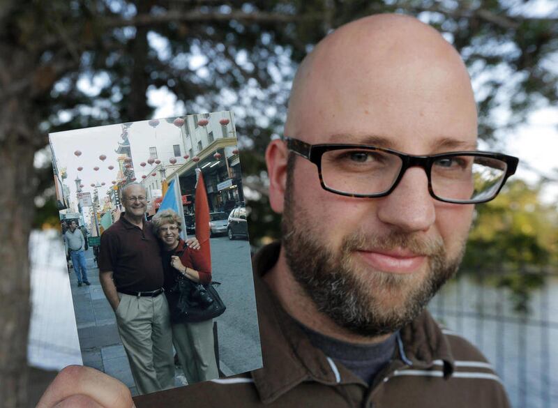 Jeremy Writebol holds a photograph of his mother and father before an interview with a reporter in Wichita, Kan., Sunday, Aug. 3, 2014. Jeremy is the son of Nancy Writebol, a missionary stricken with Ebola. Nancy Writebol is expected to fly Tuesday to the