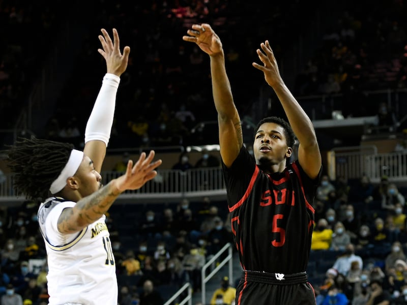 Southern Utah guard Tevian Jones, right, shoots over Michigan guard Frankie Collins