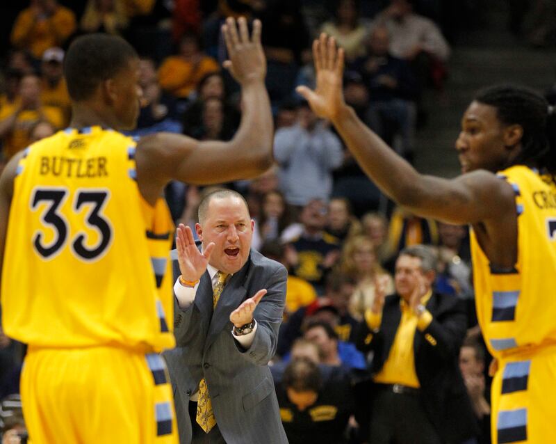 Marquette coach Buzz Williams, center, cheers on players Jimmy Butler (33) and Jae Crowder, right, against Seton Hall in the second half of an NCAA college basketball game Saturday, Feb. 19, 2011, in Milwaukee. (AP Photo/Jeffrey Phelps)