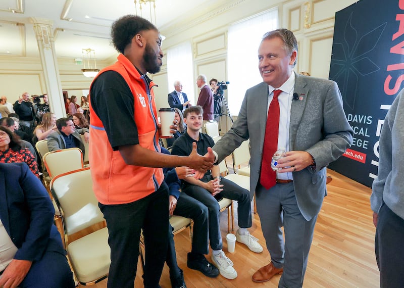 Abukar Hasan shakes hands with University of Utah President Taylor Randall at the Thomas S. Monson Center in Salt Lake City.