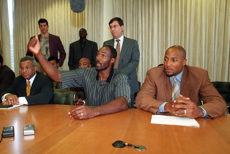 National Basketball Association's Players Union director Billy Hunter, left, and Miami Heat's Alonzo Mourning, right, flank Karl Malone of the Utah Jazz as Malone speaks out during the NBA labor talks in New York Thursday, Aug. 6, 1998. As the summer wind