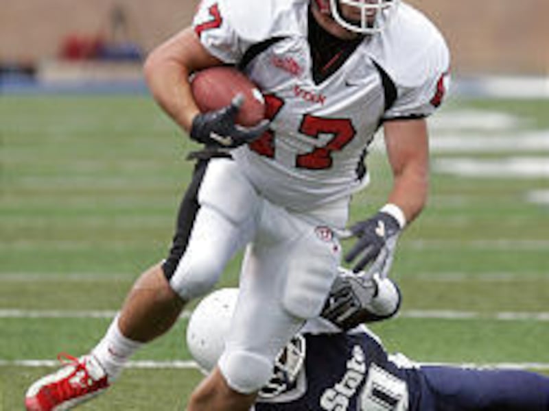 University of Utah tight end Blake Burdette runs over Utah State's Jerome Dennis en route to an 18-yard gain last Saturday.