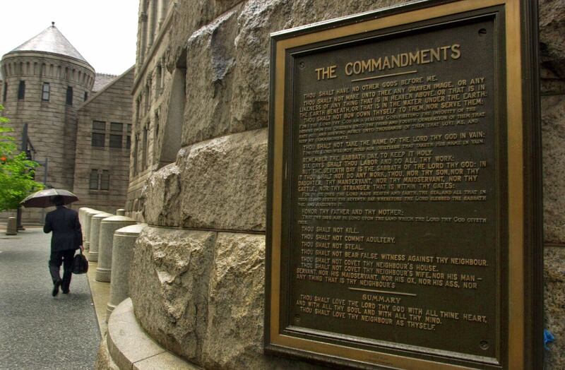 A pedestrian passes a plaque containing the Ten Commandments on the Allgheny County Courthouse in downtown Pittsburgh, Friday, April 27, 2001. The plague has become a source of controversy with some claiming it represents an illegal co-mingling of church