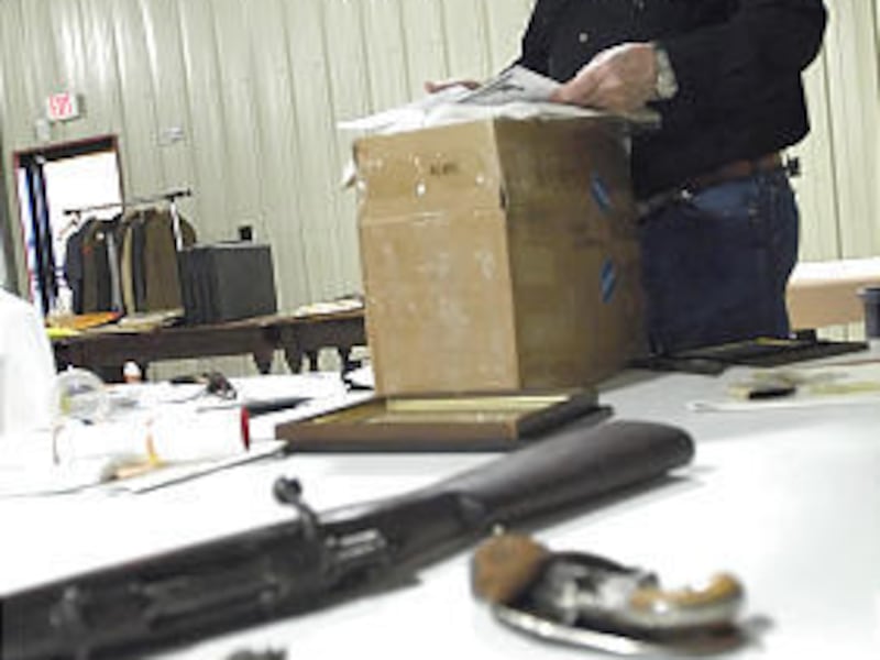Curator Tom Burke looks over Old West items, including weapons owned by Pancho Villa and Calamity Jane, that will be auctioned off this weekend in Texas.