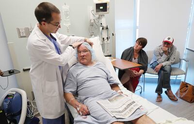 Dr. John Rolston explains a new surgical procedure for Parkinson's to patient Art Eichbauer as his children Paula and Brian listen at University Hospital in Salt Lake City on Tuesday, July 31, 2018.