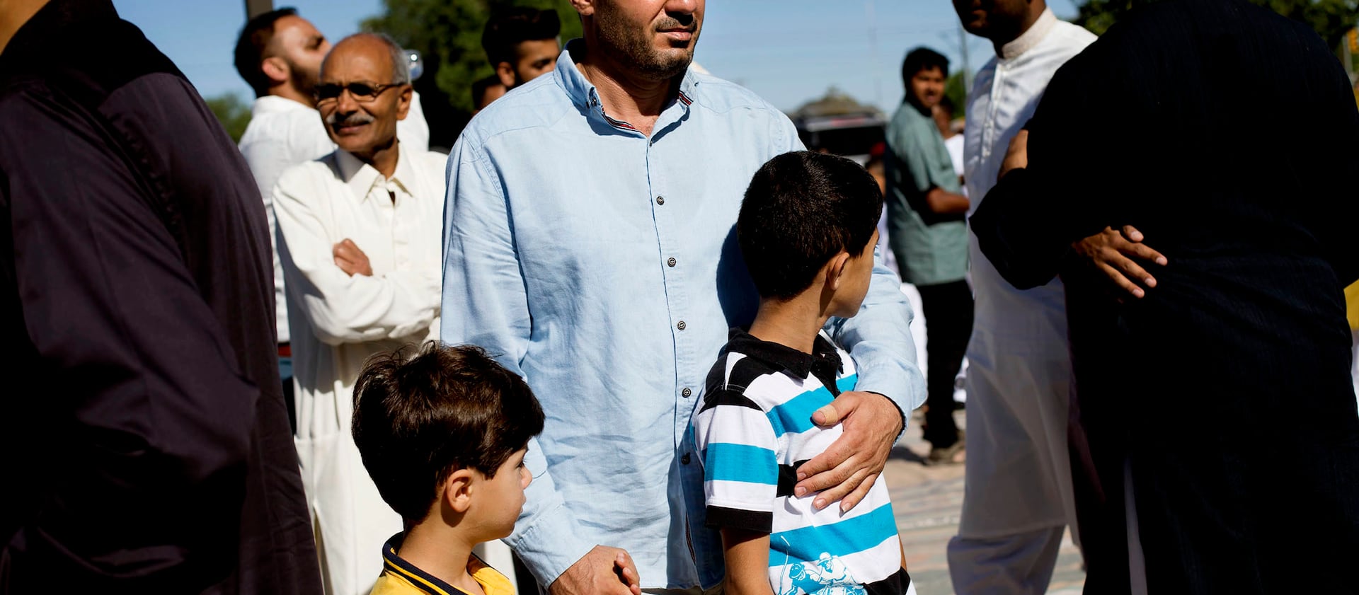 Malek Hamad holds his sons Eslam and Abdullah while searching for his wife’s cousin, after praying at the end of Ramadan, at the Khadeeja Islamic Center in West Valley City, June 25, 2017. The Hamads had been in the United States for only a month as of th