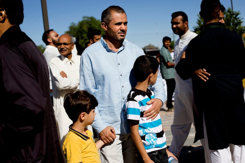 Malek Hamad holds his sons Eslam and Abdullah while searching for his wife’s cousin, after praying at the end of Ramadan, at the Khadeeja Islamic Center in West Valley City, June 25, 2017. The Hamads had been in the United States for only a month as of th