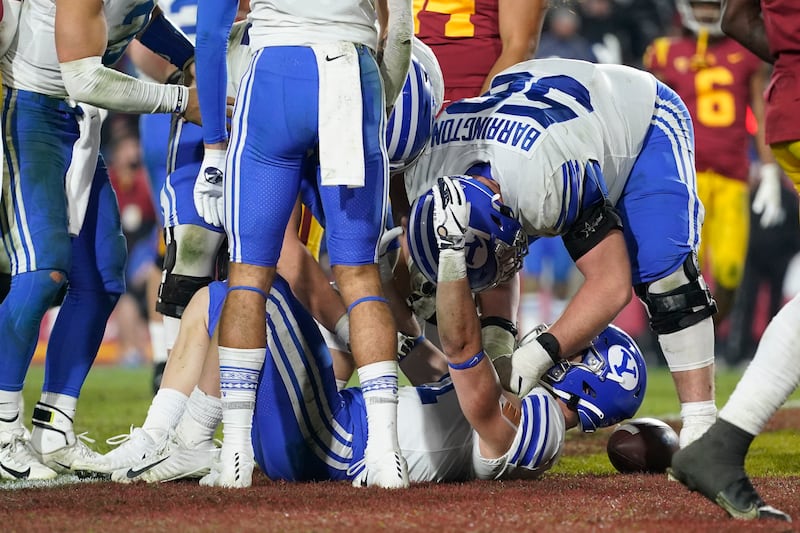 BYU running back Jackson McChesney (21) celebrates with offensive lineman Clark Barrington (56) after scoring a touchdown.