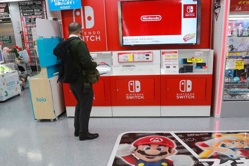 A shopper looks at Switch from Nintendo at an electronics store in Tokyo, Monday, Nov. 2, 2020. A new report suggests Nintendo will release a new Switch console model