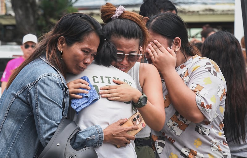 People grieve after identifying the body of a victim outside Cebu Provincial Hospital in Bogo City on Wednesday, Oct. 1, 2025.