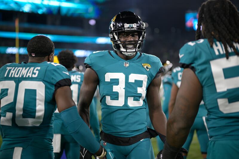 Jacksonville Jaguars linebacker Devin Lloyd (wearing teal) jogs onto the field