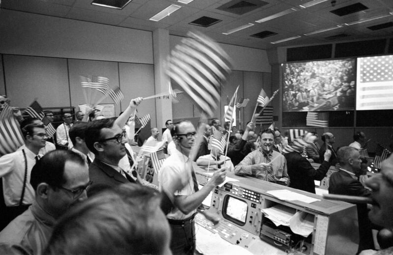 In this July 24, 1969, photo made available by NASA, flight controllers at the Mission Operations Control Room in the Mission Control Center at the Manned Spacecraft Center in Houston celebrate the successful conclusion of the Apollo 11 lunar landing miss