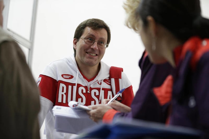 Russia's Alexei Klimov talks with Olympic news service reporters after qualifying for the final in the men's 25-meter rapid fire pistol event, at the 2012 Summer Olympics, Friday, Aug. 3, 2012, in London.