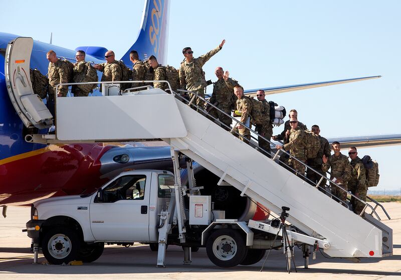 Utah National Guard soldiers wave goodbye as they are deployed to the Middle East at the Roland R. Wright Air National Guard Base in Salt Lake City on Monday, June 4, 2018.