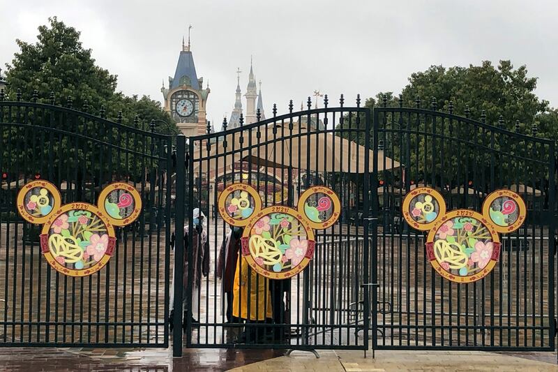 Employees stand at the gates of the Shanghai Disney Resort, which announced that it will be closed indefinitely from Saturday, in Shanghai, Saturday, Jan. 25, 2020. China’s most festive holiday began in the shadow of a worrying new virus Saturday as the death toll surpassed 40, an unprecedented lockdown that kept people from traveling was expanded to more than 50 million residents and authorities canceled a host of Lunar New Year events. (AP Photo/Fu Ting)