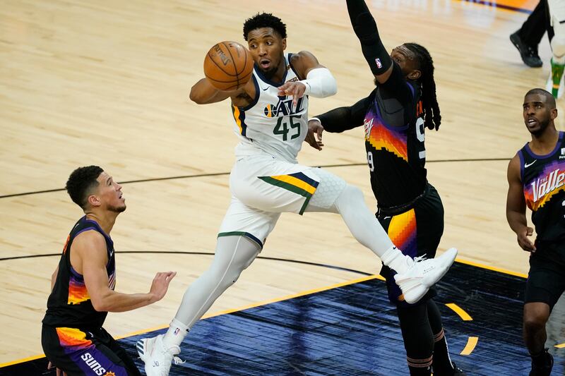 Utah Jazz guard Donovan Mitchell dishes off as Phoenix Suns forward Jae Crowder defends Wednesday, April 7, 2021, in Phoenix.