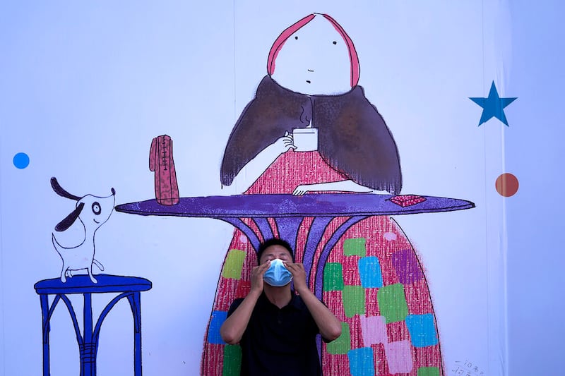A man adjusts his face mask at a shopping mall in Beijing.