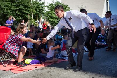 Elder Salvador Arroz, an LDS Church missionary in Utah, high-fives Grace Nagy, 12, during the Freedom Festival’s July 4th Grand Parade in Provo on Wednesday, July 4, 2018.