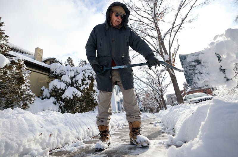 John Russell shovels the sidewalk in front of his house after a snowstorm in Salt Lake City on Thursday, Dec. 15, 2022.