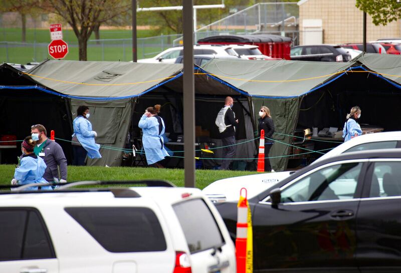 In this May 4, 2020 file photo, healthcare workers run a coronavirus testing site for Smithfield employees in the Washington High School parking lot on Monday, May 4, 2020 in Sioux Falls, S.D.