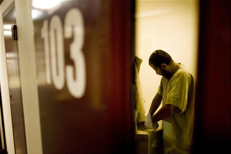 A detainee at the U.S. Naval Base in Guantanamo Bay, Cuba, washes his hands inside his cell Wednesday. The release of five Algerians is called a blow to the Bush administration's policy to keep terror suspects locked up without charges.