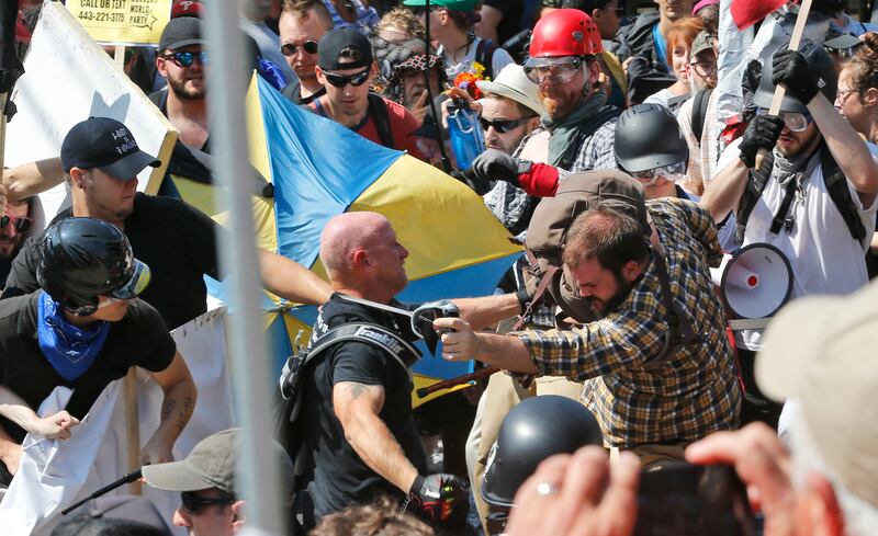 FILE - In this Aug. 12, 2017 file photo, white nationalist demonstrators clash with counter demonstrators at the entrance to Lee Park in Charlottesville, Va. The leader of a Southern California white supremacist group and three other members have been arr