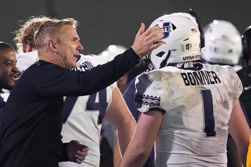 Utah State coach Blake Anderson taps QB Logan Bonner on the head during game against San Jose State, Nov. 13, 2021.