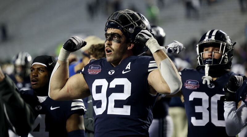BYU defensive lineman Tyler Batty joins with his teammates in singing to the fans as they leave the field after losing to UAB in the Independence Bowl.