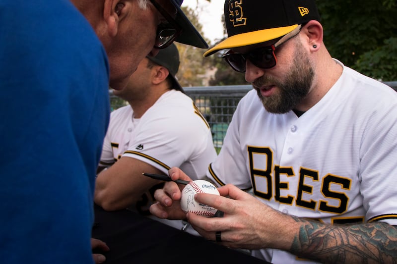 Grant Gelt signs a baseball at the 25th anniversary of “The Sandlot.”