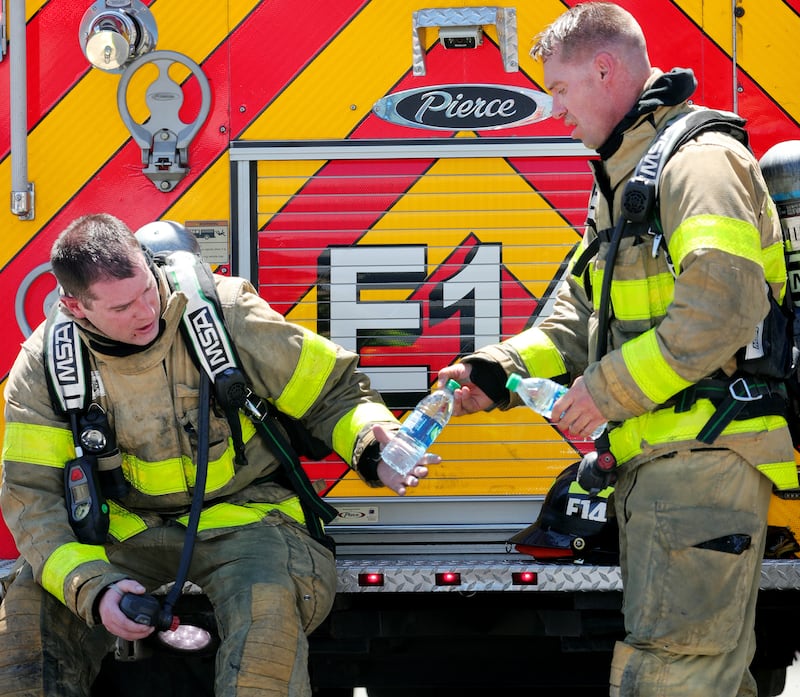 A pair of firefighters hydrate after Salt Lake and West Valley fire crews responded to a fire at RM Rubber Co. in Salt Lake City on Monday, July 22, 2019. A heat advisory for Monday and Tuesday has been issued as temperatures top 100 degrees.