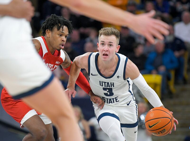 Utah State guard Steven Ashworth (wearing white) dribbles as Bradley guard James Weathers defends
