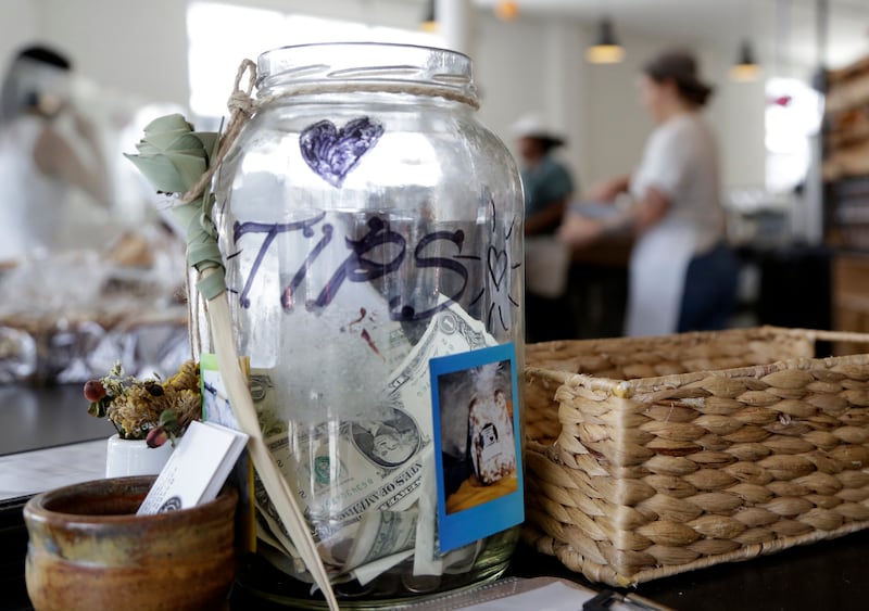 In this Wednesday, June 20, 2018 photo, a tip jar sits on the counter at Zak the Baker in Miami. (AP Photo/Lynne Sladky)