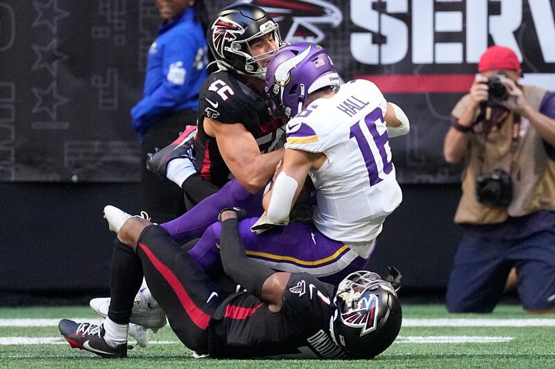 Minnesota Vikings quarterback Jaren Hall (16) is tackled by Atlanta Falcons linebacker Kaden Elliss (55) and cornerback Jeff Okudah (1) during the first half of an NFL football game, Sunday, Nov. 5, 2023, in Atlanta. Hall was injured on the play.