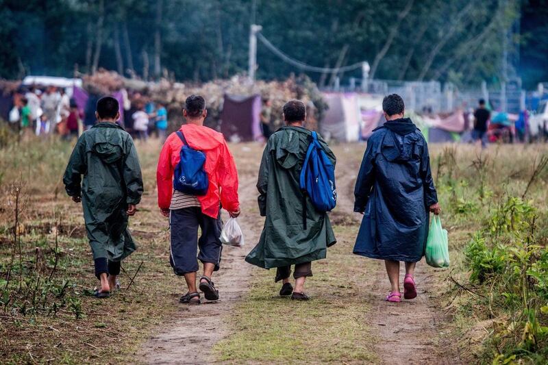 Men walk in the migrant camp at the border between Serbia and Hungary at Horgos, Northern Serbia, Tuesday, July 26, 2016.  There are around 1,400 migrants staying in Northern Serbia waiting for the opportunity to continue their journey to central Europe,
