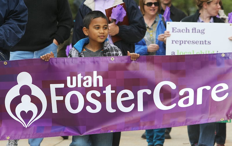 Tayler Sumsion walks with his family and others around the Salt Lake City-County Building to honor foster care families.