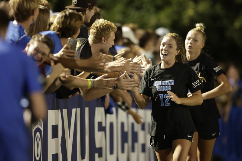 Members of the BYU soccer team high-five fans after the Cougars upset No. 1-ranked UCLA Thursday night at Smith Field in Provo.