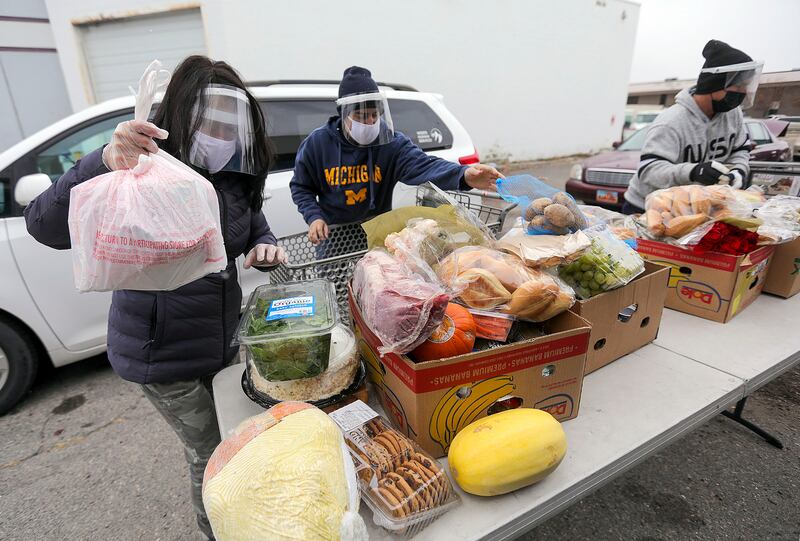 Durrell Annis, left, Damian Aguilera and Reid Blair, from Catholic Community Services load food onto a table for those in need in Ogden in 2020. Utah was ranked the most charitable state in the nation in 2020 by WalletHub.com