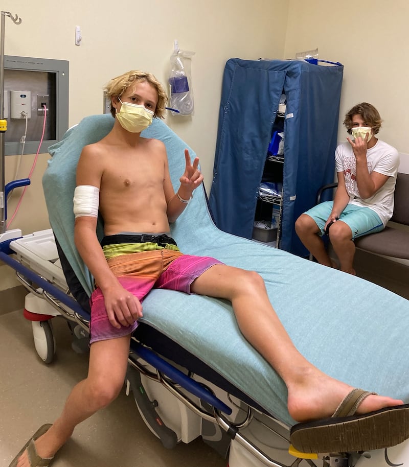 Teen surfer Doyle Nielsen receives treatment at a hospital in Florida following a shark attack on Sept. 9, with his brother Logan nearby.