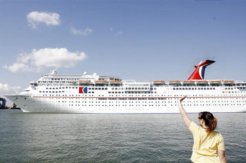 Galveston resident Claire Gergora waves Saturday as the Carnival Cruise ship Ecstasy pulls into the Galveston shipping channel for the first time since Hurricane Ike struck in mid-September. "I'm so happy they're back," said Gergora, "it is like we are fi