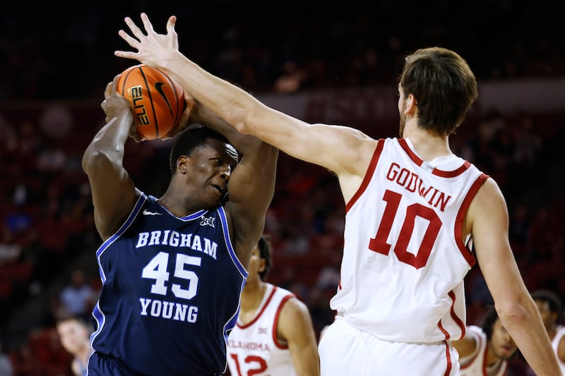 BYU forward Fousseyni Traore (45) is defended by Oklahoma forward Sam Godwin (10) during the first half of an NCAA college basketball game Tuesday, Feb. 6, 2024, in Norman, Okla.