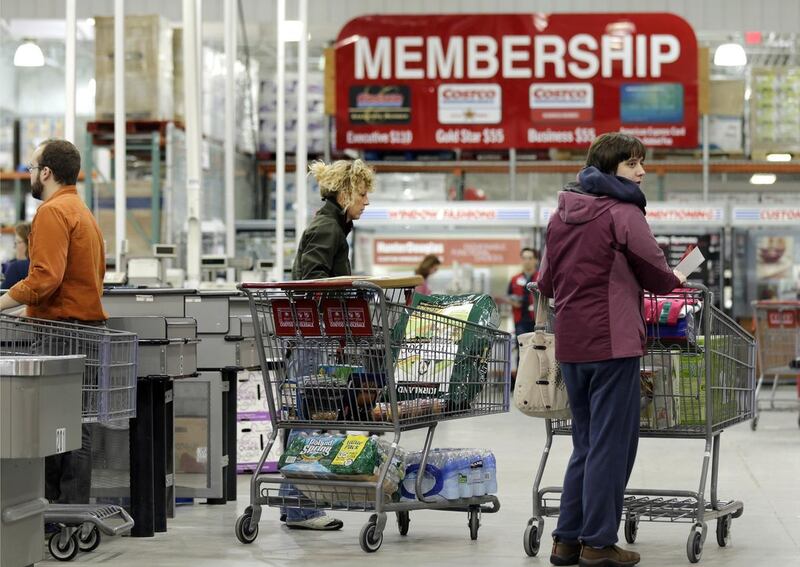In this Tuesday, March 5, 2013, photo, shoppers push their carts at the Costco store in Nashua, N.H. Costco's fiscal second-quarter net income climbed 39 percent as it pulled in more money from membership fees, sales improved and it recorded a large tax