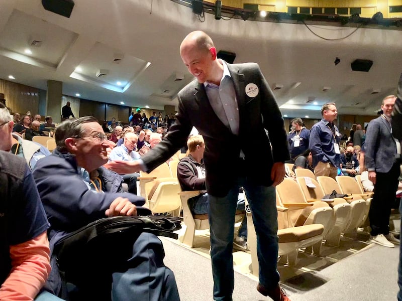 Evan McMullin shakes hands with a member of the audience at the Democratic State Convention
