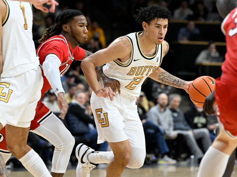 Colorado guard KJ Simpson (2) drives past Utah guard Deion Smith in the first half of an NCAA collegge basketball game Saturday, Feb. 24, 2024, in Boulder, Colo.